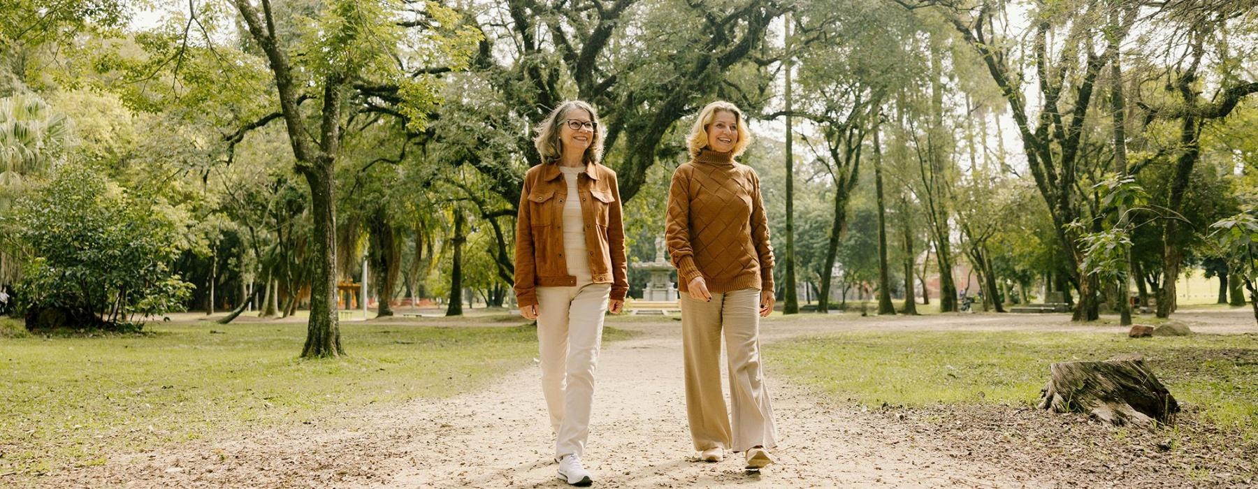 Two women walking on a path in a park